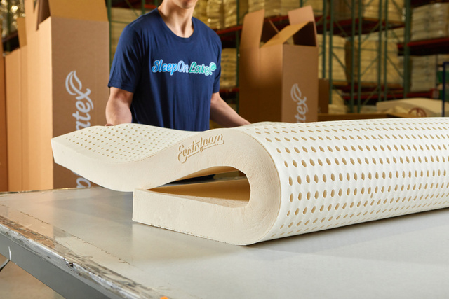 warehouse worker folding an Earthfoam mattress