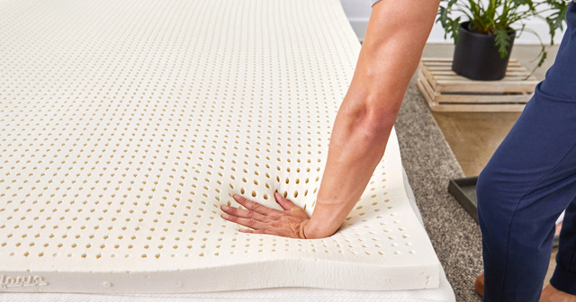 hand pressing on foam mattress